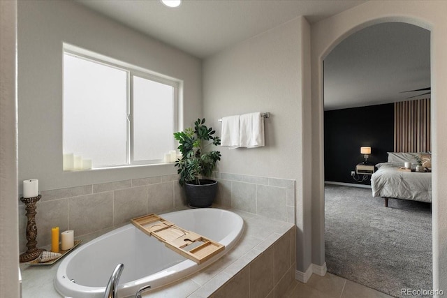ensuite bathroom featuring ensuite bathroom, a garden tub, and tile patterned flooring