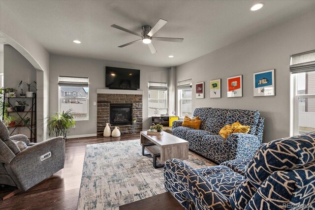 living area with wood finished floors, a ceiling fan, a fireplace, and recessed lighting