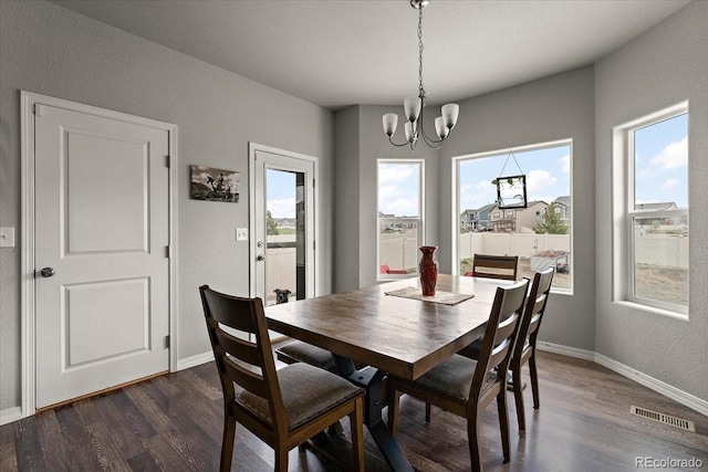 dining room with dark wood finished floors, visible vents, baseboards, and a notable chandelier
