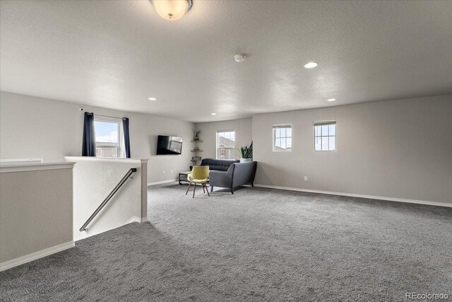 interior space with a textured ceiling, carpet floors, and recessed lighting