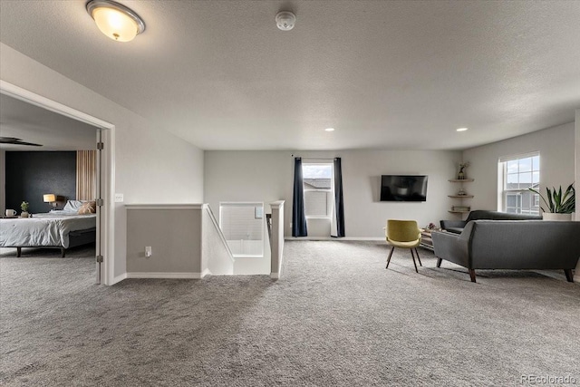 carpeted living room featuring a textured ceiling, baseboards, and recessed lighting