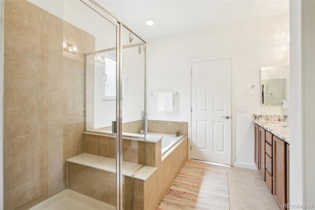 full bath featuring vanity, tile patterned flooring, a shower stall, and a garden tub