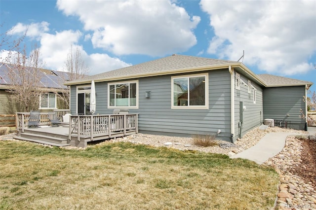 back of property with a wooden deck and a yard