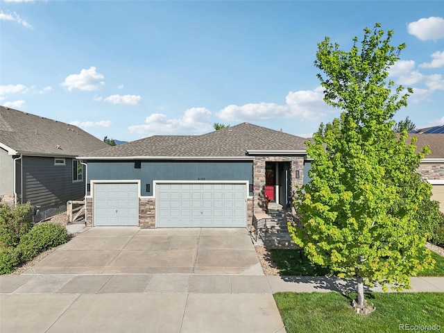 9139 Flora St, Arvada, CO 80005 - view of front of house with an attached garage, driveway, stone siding, stucco siding, and roof with shingles