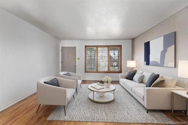 living room featuring wood-type flooring and a textured ceiling