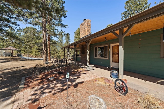 exterior space featuring a chimney and a patio area