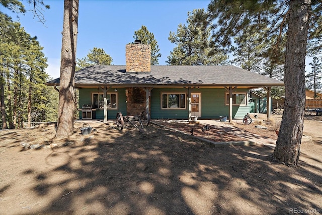 back of house with a chimney