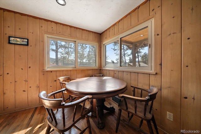 dining room featuring wooden walls and wood finished floors