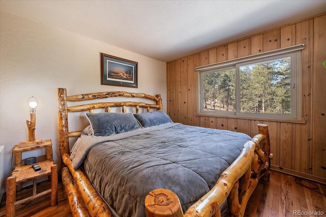 bedroom featuring wood walls and wood-type flooring