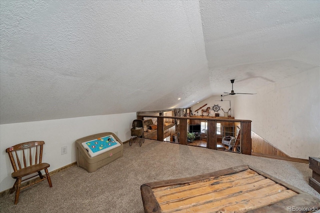 sitting room featuring lofted ceiling, carpet flooring, and a textured ceiling