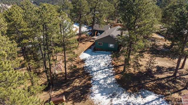 bird's eye view with a wooded view