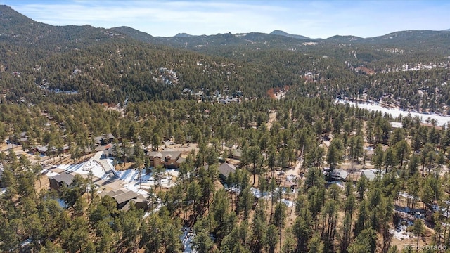 drone / aerial view featuring a forest view and a mountain view