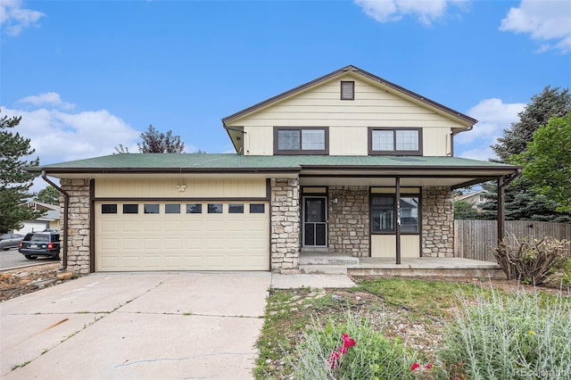14190 E Gunnison Pl, Aurora, CO 80012 - view of front of home with stone siding, a porch, concrete driveway, and a garage