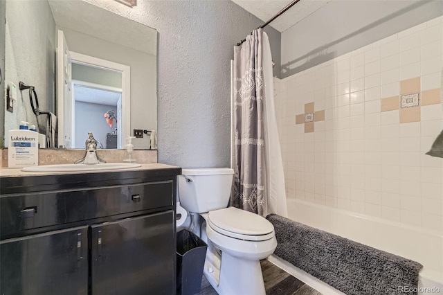 full bath with shower / tub combo, toilet, a textured wall, vanity, and wood finished floors