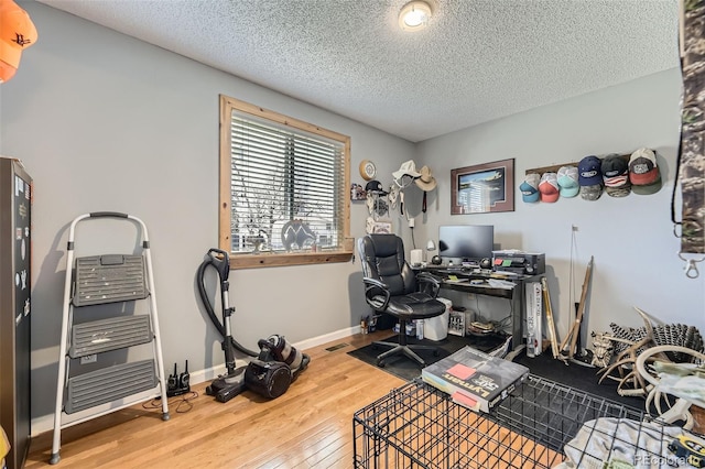 office space with baseboards, hardwood / wood-style flooring, and a textured ceiling