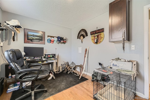 office space with baseboards, wood finished floors, and a textured ceiling