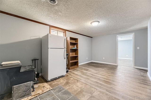 empty room featuring visible vents, baseboards, wood finished floors, and a textured ceiling