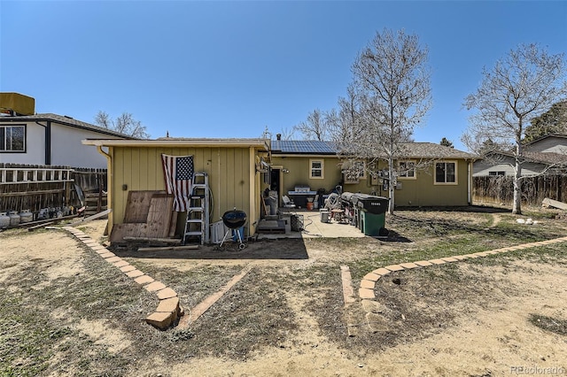 back of house with a patio, solar panels, and a fenced backyard