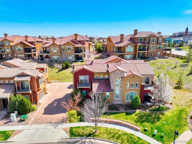 view of front of home featuring a tile roof, stucco siding, decorative driveway, and a residential view