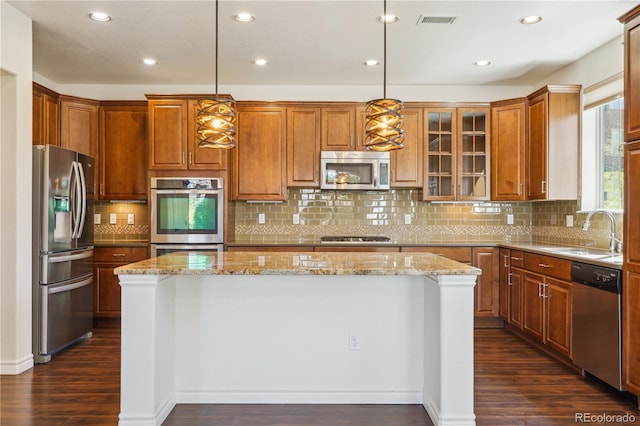 kitchen with a sink, dark wood finished floors, recessed lighting, a center island, and appliances with stainless steel finishes