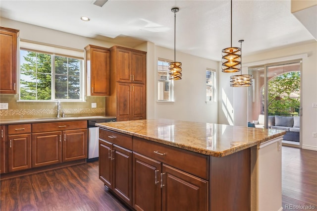 kitchen with plenty of natural light, dark wood finished floors, a center island, and a sink