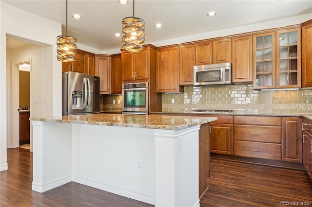 kitchen with a kitchen island, stainless steel appliances, light stone countertops, and dark wood-type flooring