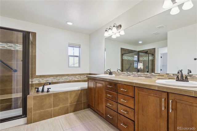 full bath with double vanity, a garden tub, a shower stall, and a sink