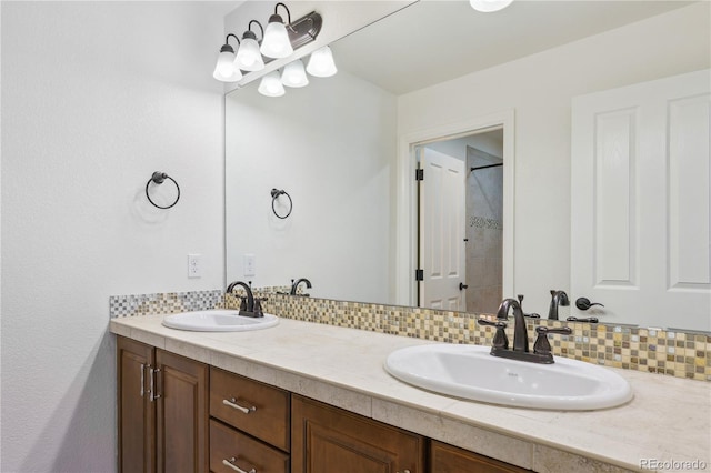 full bath with a shower, double vanity, and a sink