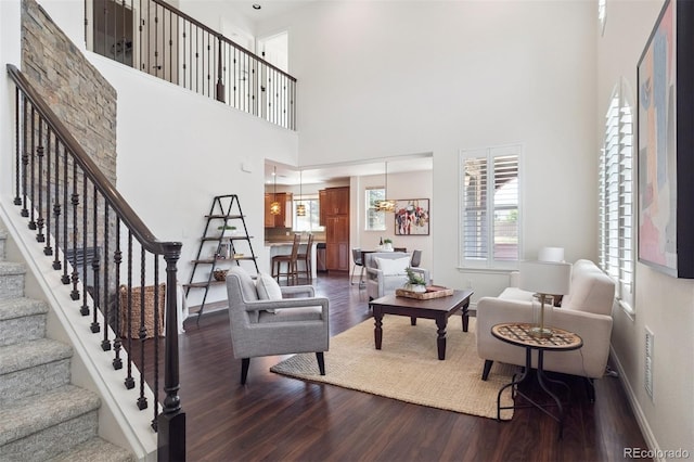 9588 Firenze Way, Highlands Ranch, CO 80126 - living room featuring wood finished floors, a towering ceiling, and stairs