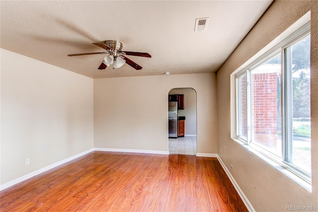 9150 Lilly Ct, Thornton, CO 80229 - spare room with arched walkways, plenty of natural light, ceiling fan, and wood finished floors