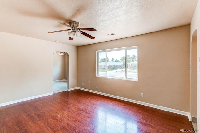 9150 Lilly Ct, Thornton, CO 80229 - empty room featuring arched walkways, ceiling fan, wood finished floors, and a textured ceiling