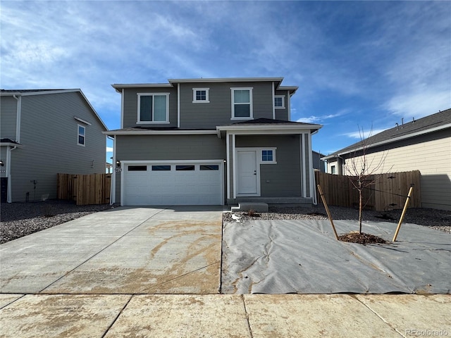 traditional home featuring fence, a garage, and driveway