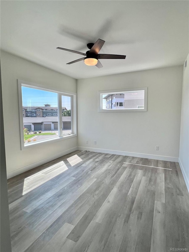 unfurnished room with ceiling fan, hardwood / wood-style flooring, and plenty of natural light