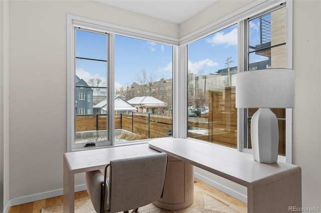 office area featuring plenty of natural light, wood finished floors, and baseboards