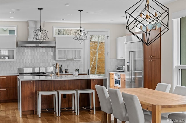 kitchen featuring appliances with stainless steel finishes, wood finished floors, light countertops, and modern cabinets