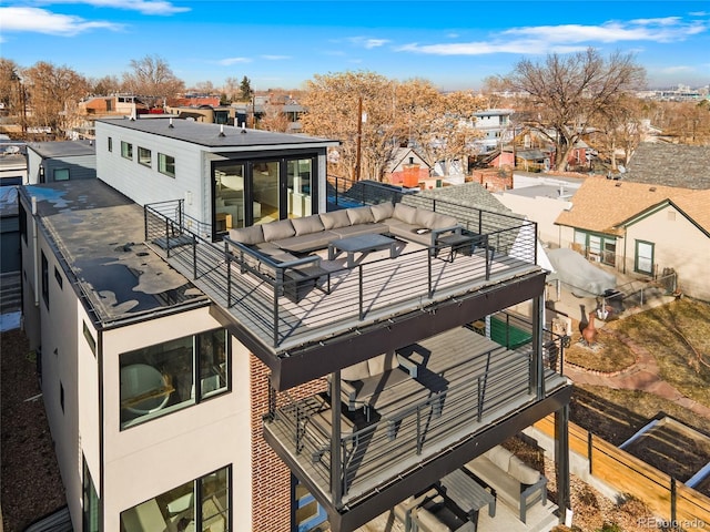 rear view of property with a balcony, a residential view, and stucco siding