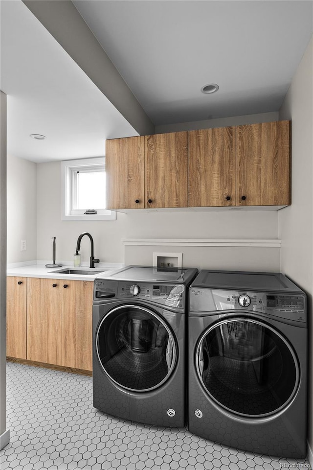 laundry room with cabinet space, separate washer and dryer, and a sink