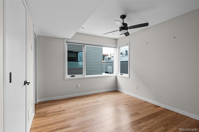 unfurnished bedroom with ceiling fan, light wood-type flooring, and baseboards