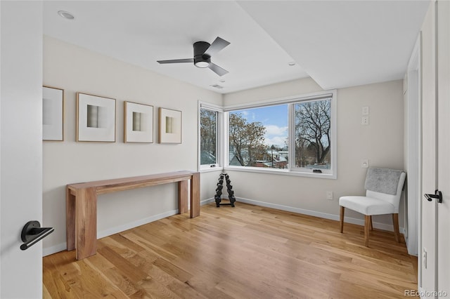 sitting room with light wood-style floors, ceiling fan, and baseboards