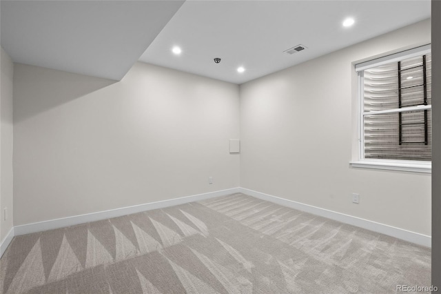 spare room with light carpet, baseboards, visible vents, and recessed lighting