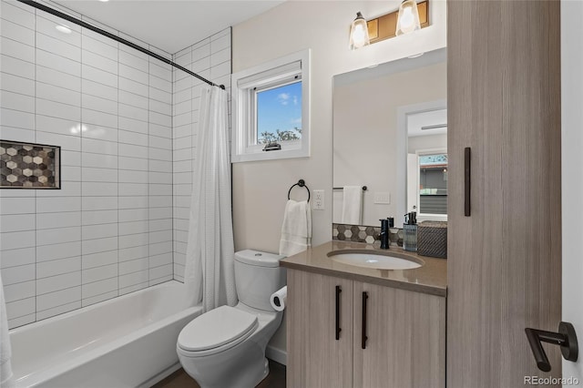 bathroom featuring shower / bathtub combination with curtain, toilet, and vanity