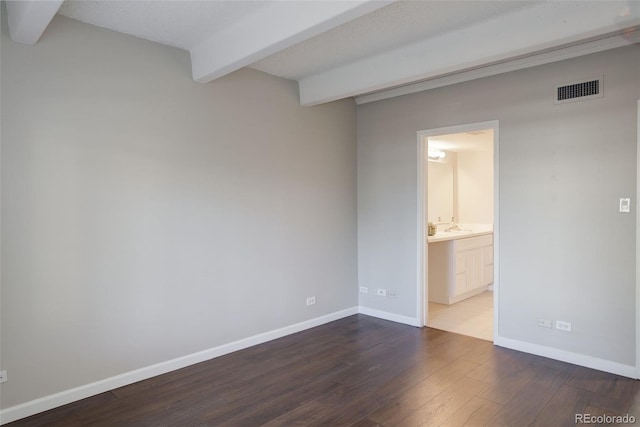 unfurnished bedroom with dark wood-type flooring, beamed ceiling, visible vents, and baseboards