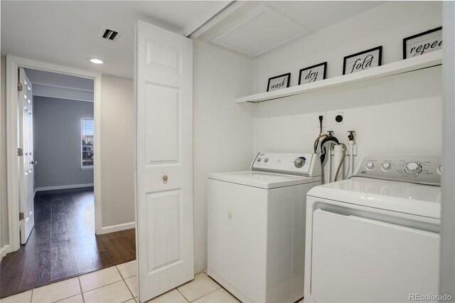 washroom featuring laundry area, light tile patterned floors, baseboards, visible vents, and separate washer and dryer