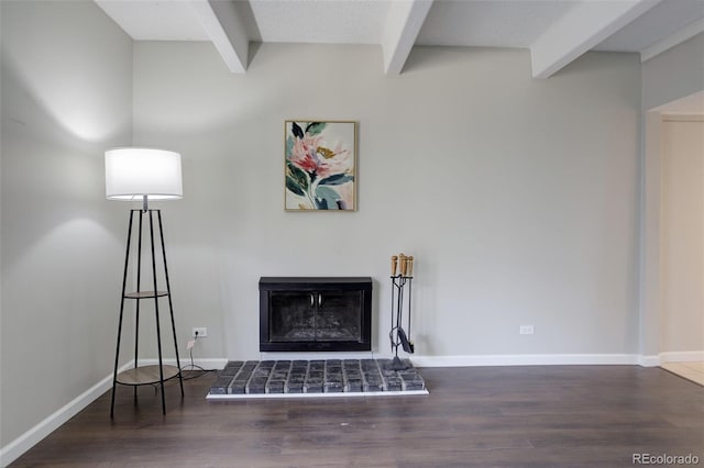 living area featuring beamed ceiling, baseboards, a fireplace with raised hearth, and wood finished floors