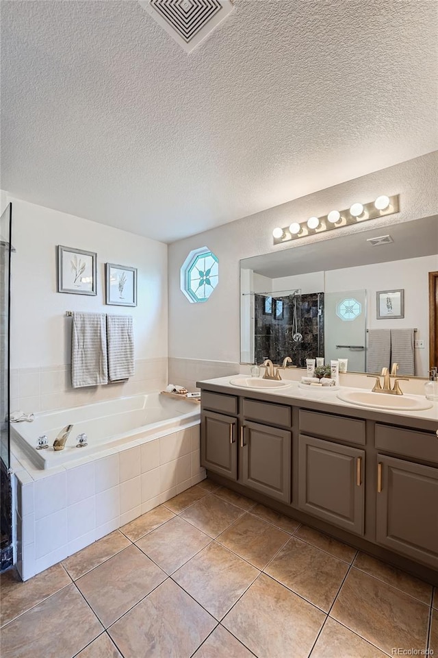 5394 S Valdai Way, Aurora, CO 80015 - full bath with double vanity, a bath, a textured ceiling, tile patterned flooring, and tiled shower