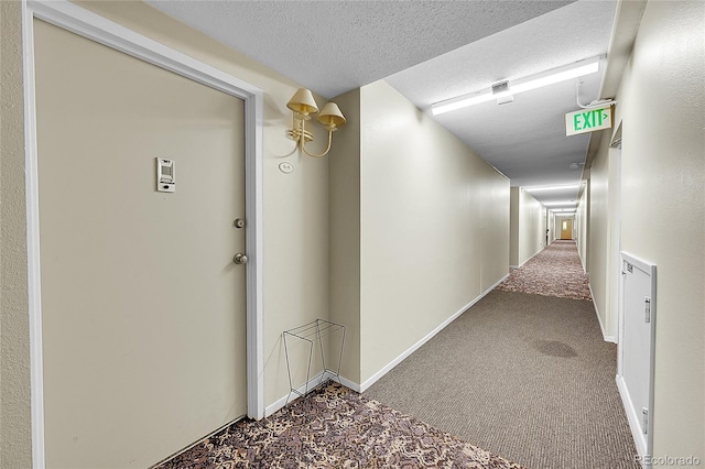 hallway featuring carpet and a textured ceiling