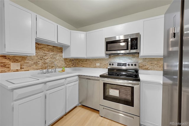 kitchen with sink, white cabinetry, stainless steel appliances, and tasteful backsplash