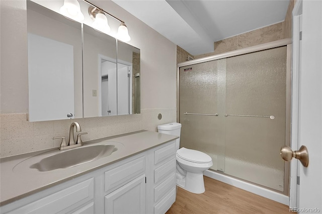 bathroom with vanity, backsplash, toilet, and an enclosed shower