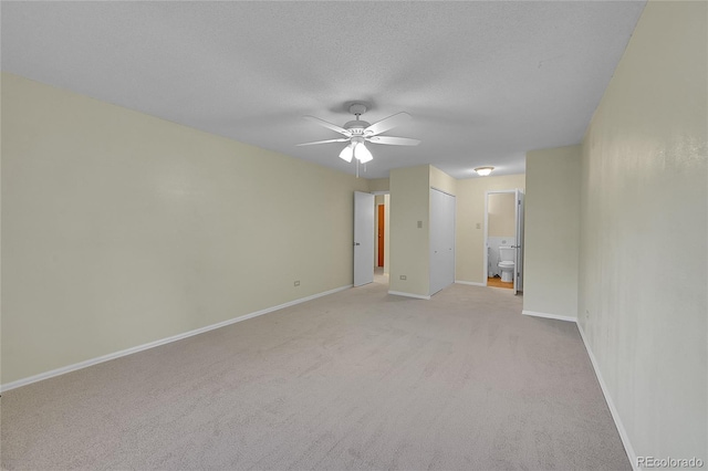 carpeted empty room with ceiling fan and a textured ceiling