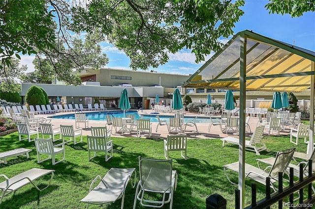 view of swimming pool featuring a lawn and a patio